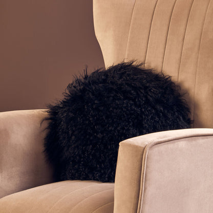 Black fluffy pillow on a beige sofa against a brown wall