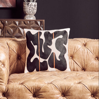 Brown tufted sofa with a decorative pillow in a living room setting.