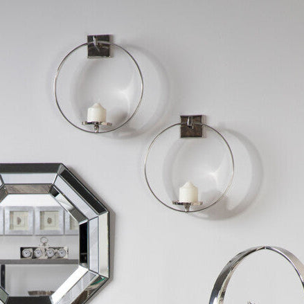Chrome bar cart and shelf against a white wall with decorative items.