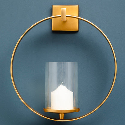 Gold wall sconce with a candle against a blue background