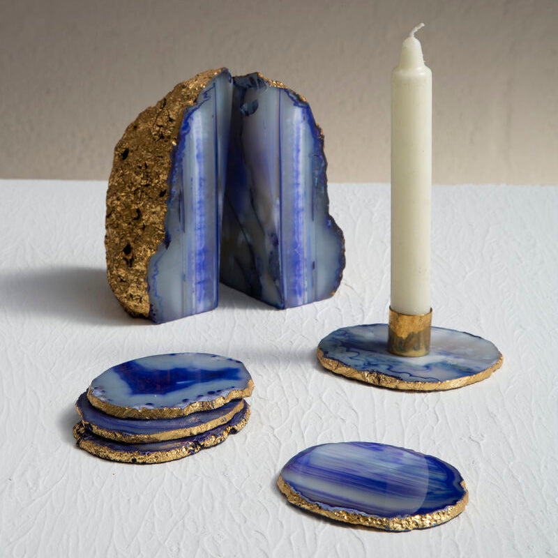 Blue agate coasters and candle holder on a white surface with a neutral background