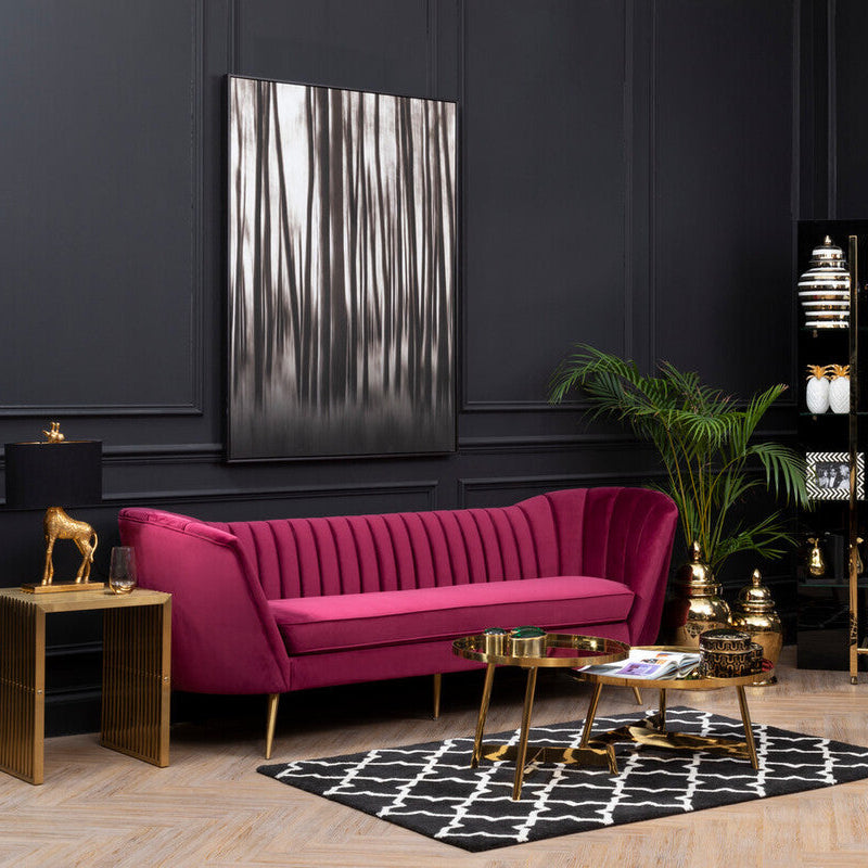 Modern living room with a pink sofa, gold accents, and decorative elements.