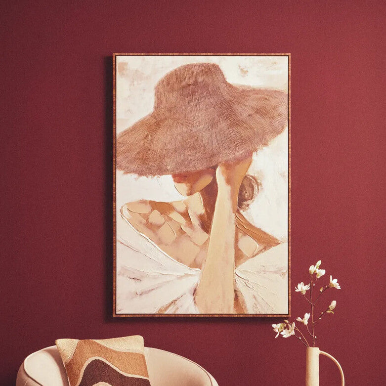 Beige armchair with a side table and decorative elements against a red wall with a framed artwork.