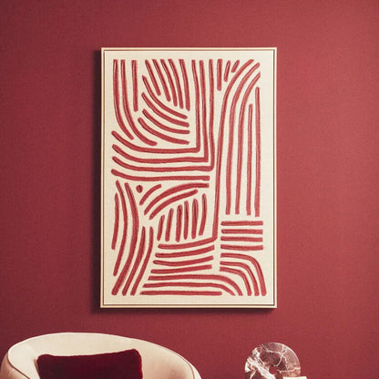 Modern interior with a pink chair, round table, and abstract red and white painting on a red wall.