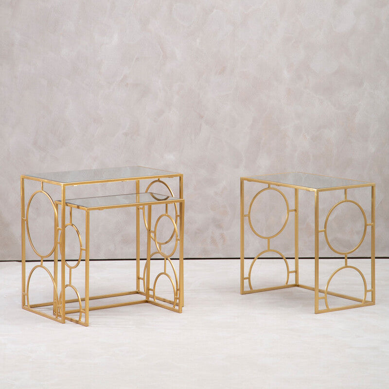 Two gold side tables with geometric designs on a light gray background