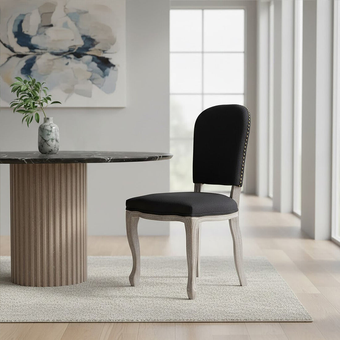 Dining room with a black upholstered chair and marble table.