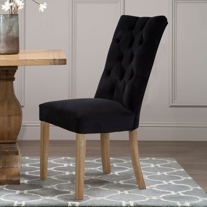 Black upholstered chair with wooden legs in a room setting.