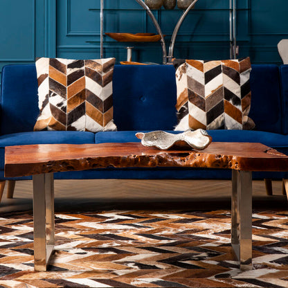Blue sofa with patterned cushions and a wooden coffee table in a room with blue walls.
