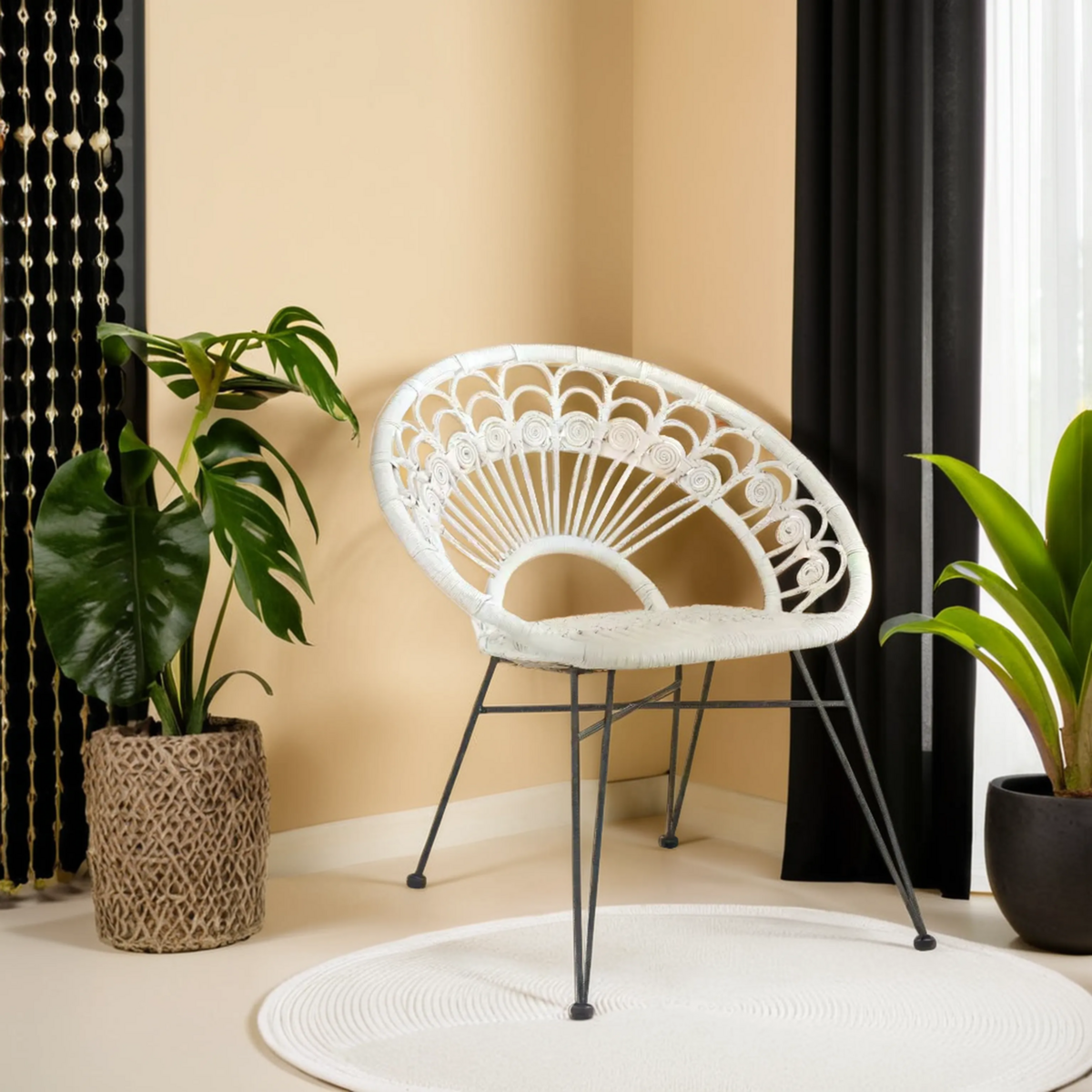 White wicker chair with black metal legs in a room with plants and curtains.