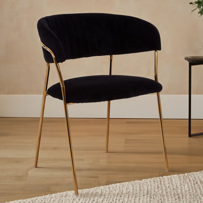Black upholstered chair with gold legs on a wooden floor.