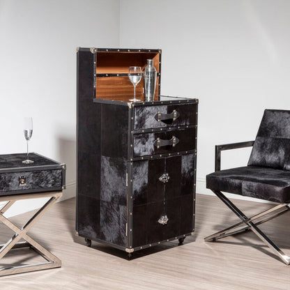 Black leather furniture set including a cabinet, side table, and chair on a light wood floor.