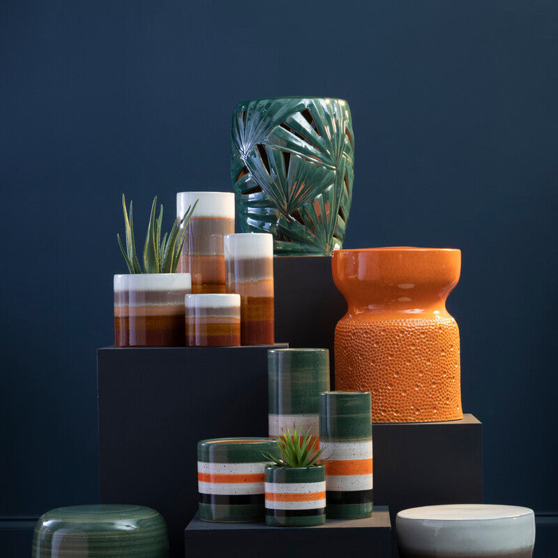 Collection of colorful ceramic vases and planters on a dark background