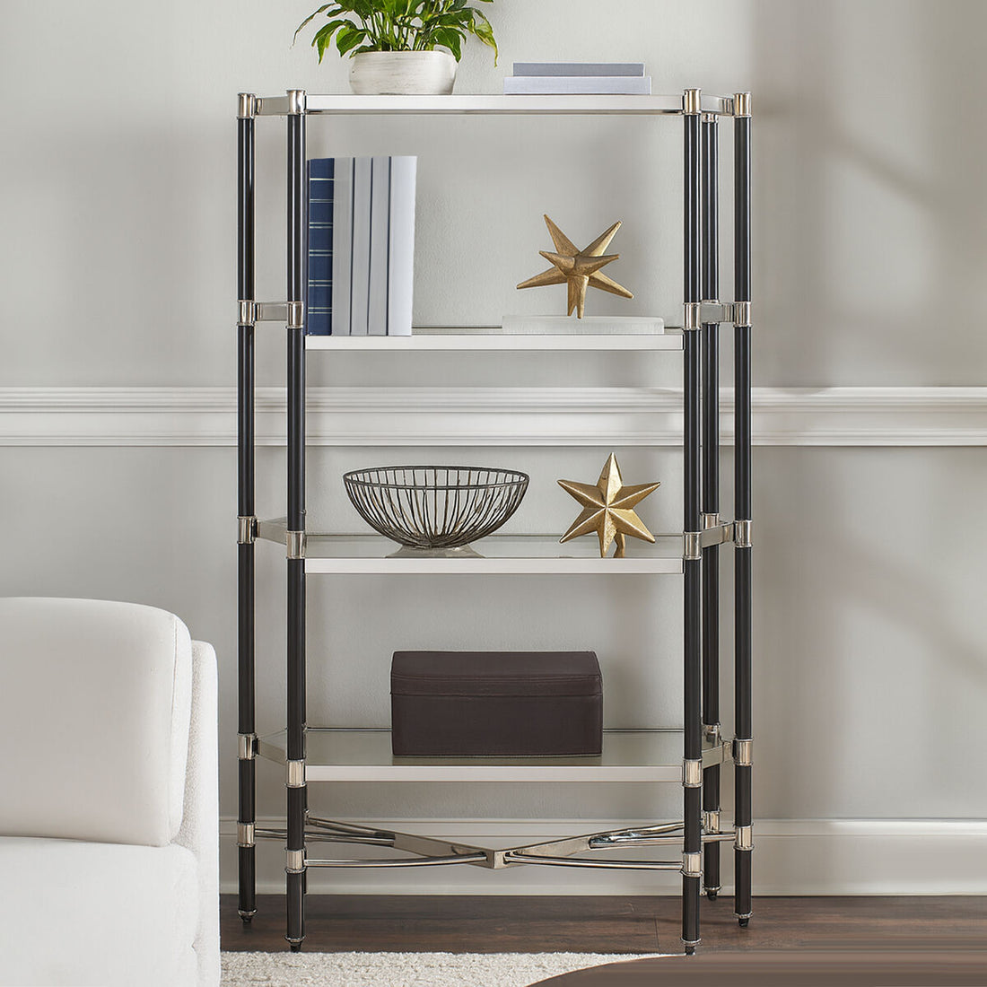 Glass shelf unit with decorative items against a neutral wall