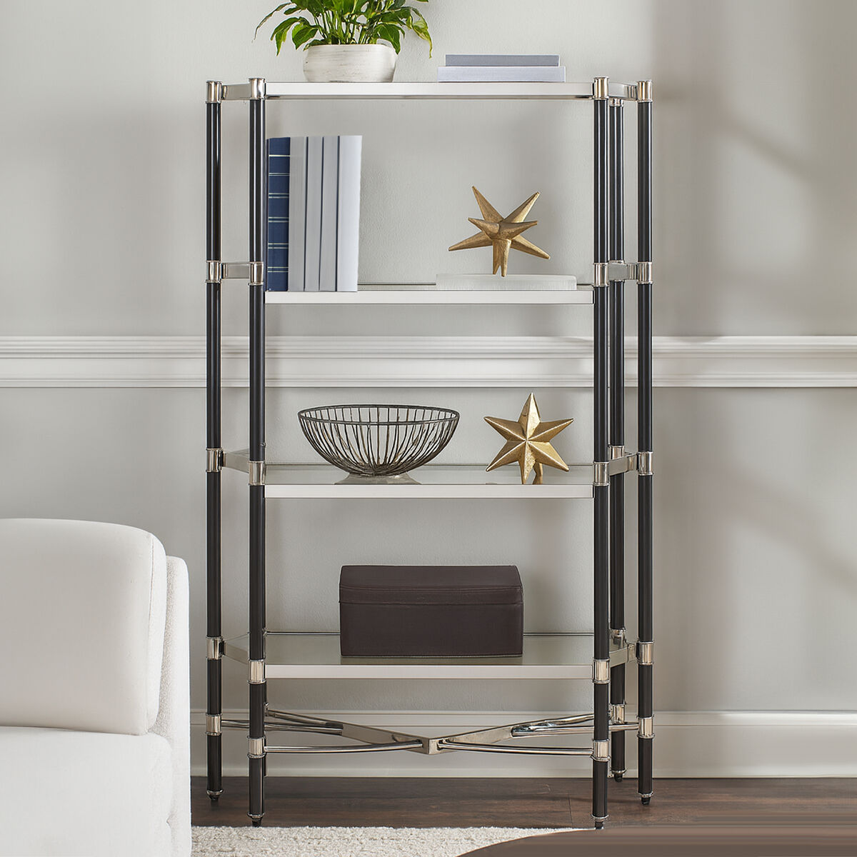 Glass shelf unit with decorative items against a neutral wall