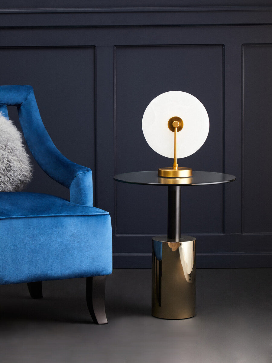 Blue armchair with a fluffy cushion in a room with dark paneling and gold 