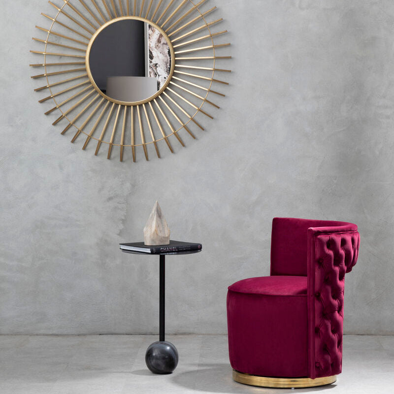 Modern interior with a gold-framed mirror and a pink chair against a gray wall.