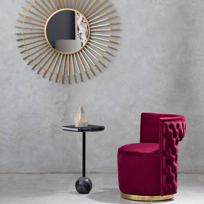 Modern interior with a gold-framed mirror and a pink chair against a gray wall.