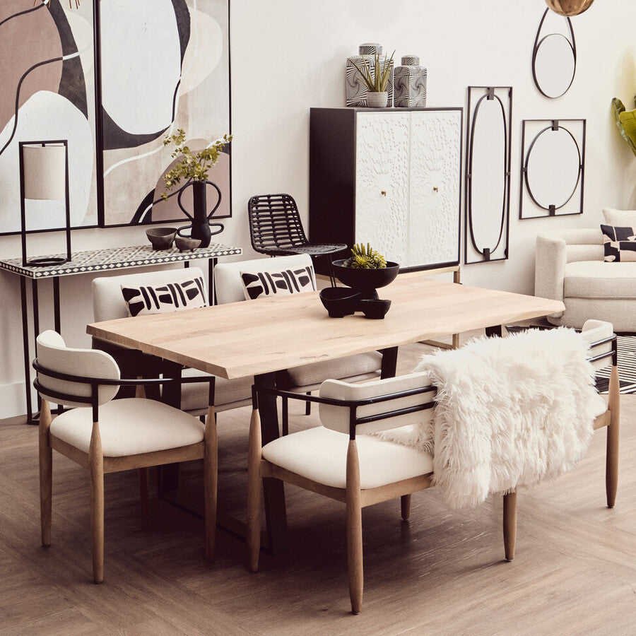 Modern dining room with wooden table and chairs, abstract art on the wall, and decorative elements.