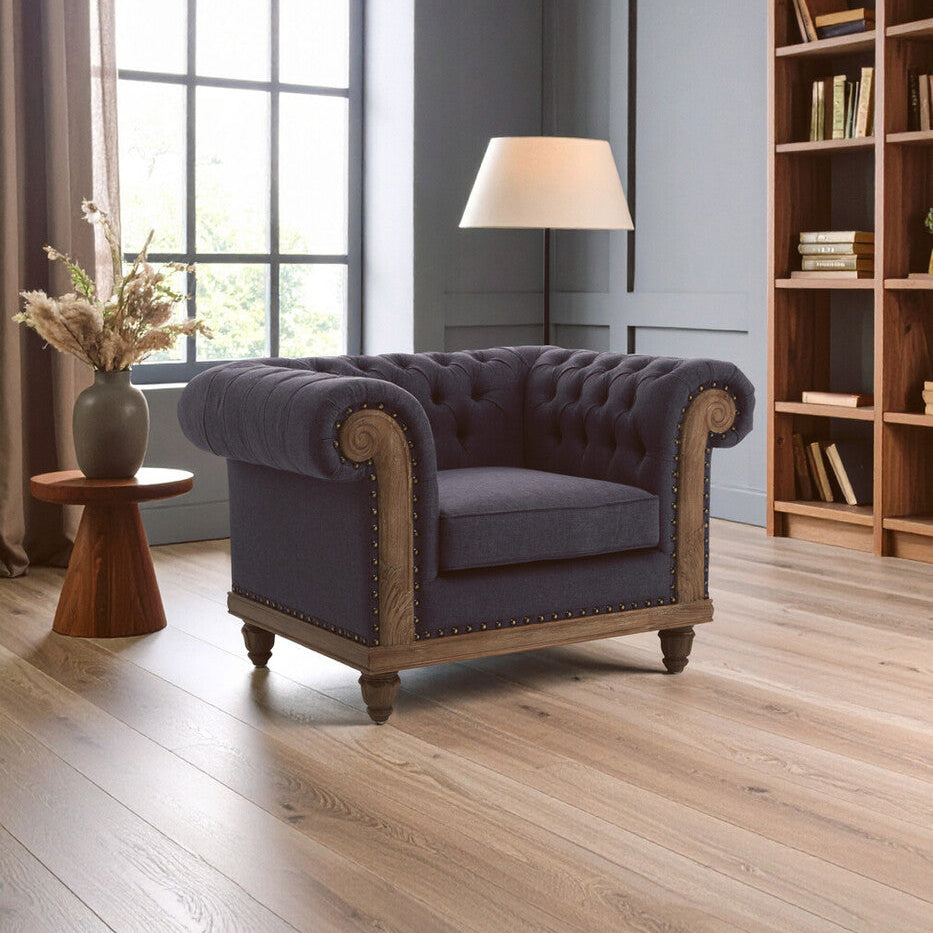 Purple armchair in a room with wooden floor, bookshelf, and window.