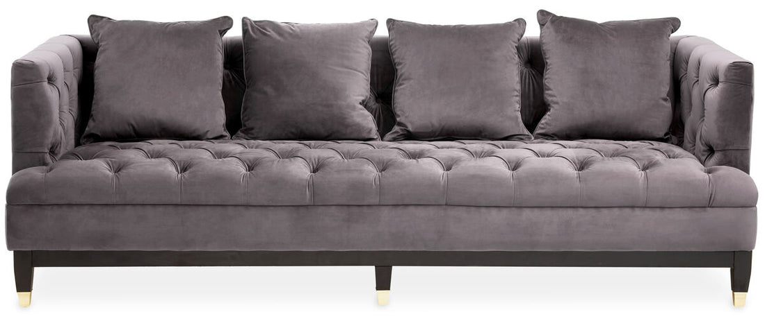 Gray tufted sofa with four cushions on a white background