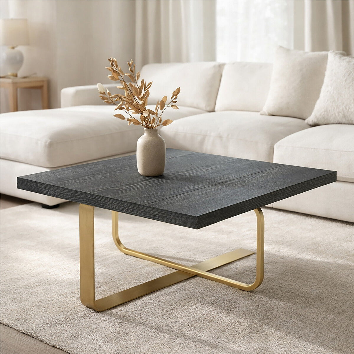 Modern coffee table with dark surface and gold legs in a living room setting.