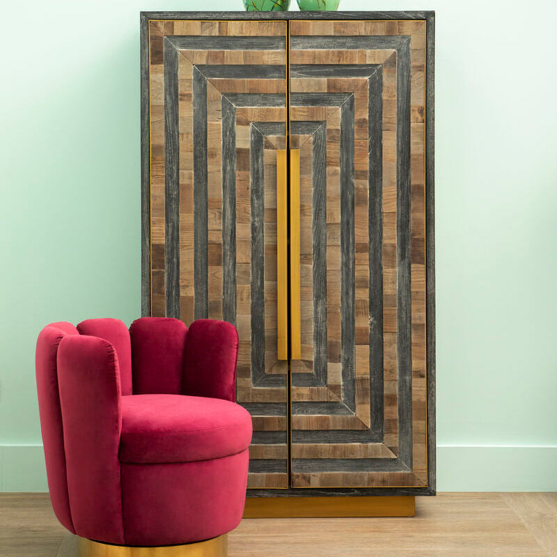 Wooden cabinet with decorative design next to a red chair on a wooden floor.