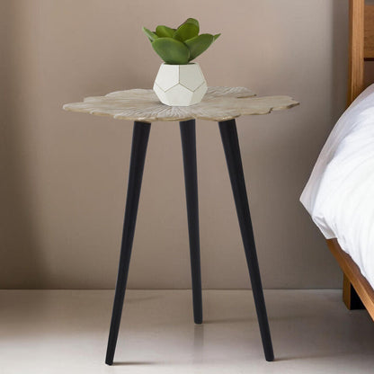 Small round table with a plant next to a bed in a bedroom setting