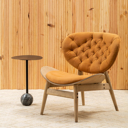 Orange chair with wooden legs against a wooden paneled wall.