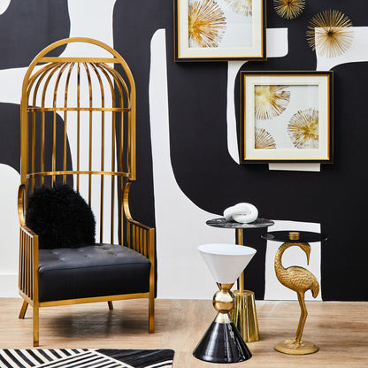 Decorative interior setting with gold birdcage chair, black and white rug, and wall art.