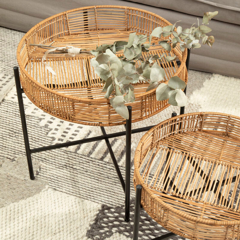 Two round wicker tables with a black metal frame on a textured surface.