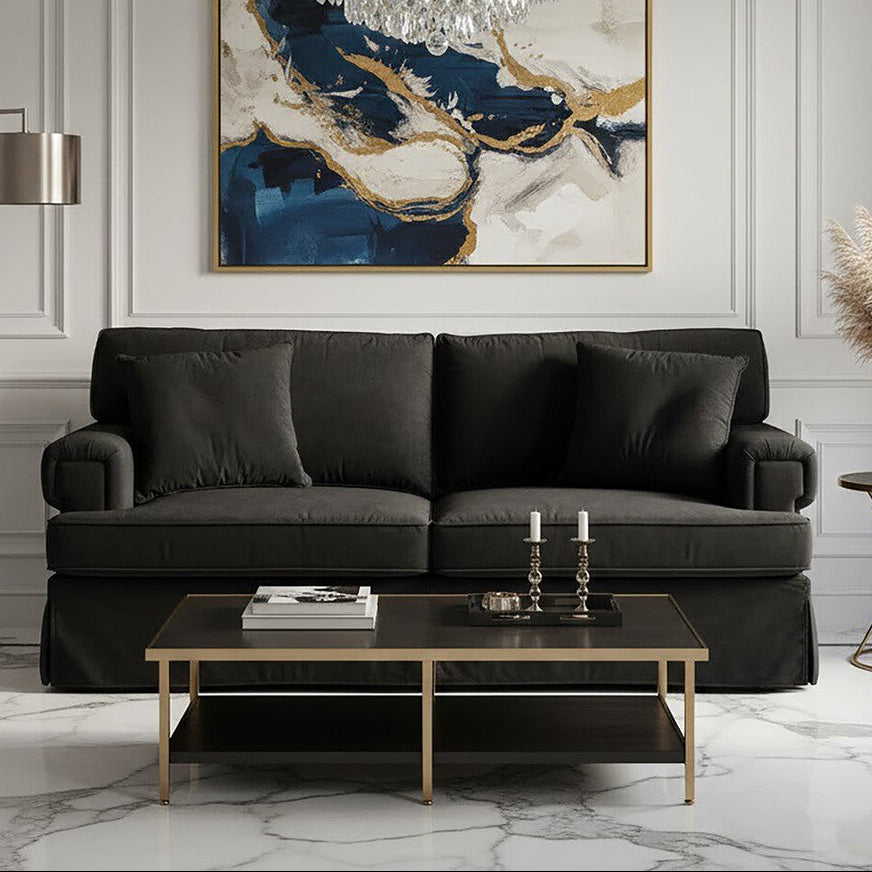 Modern living room with a black sofa, coffee table, and decorative elements.