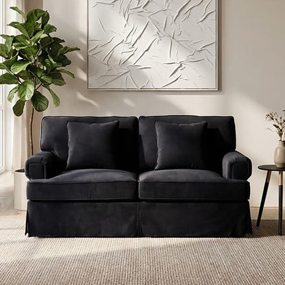 Black sofa in a living room with abstract art and plant decor