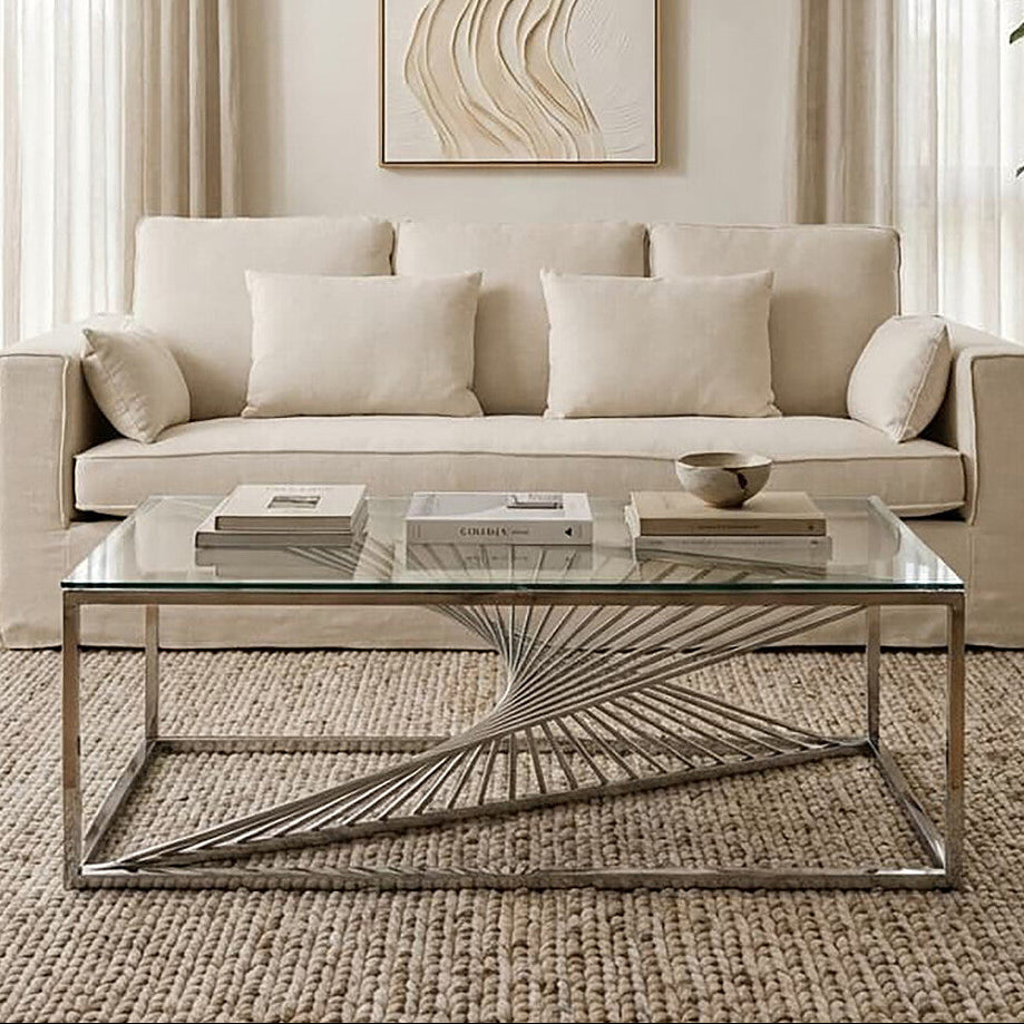 Modern living room with a beige sofa, glass coffee table, and abstract wall art.
