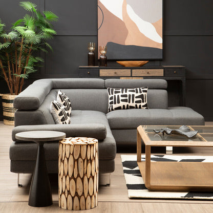 Modern living room with gray sectional sofa, wooden coffee table, and abstract wall art.