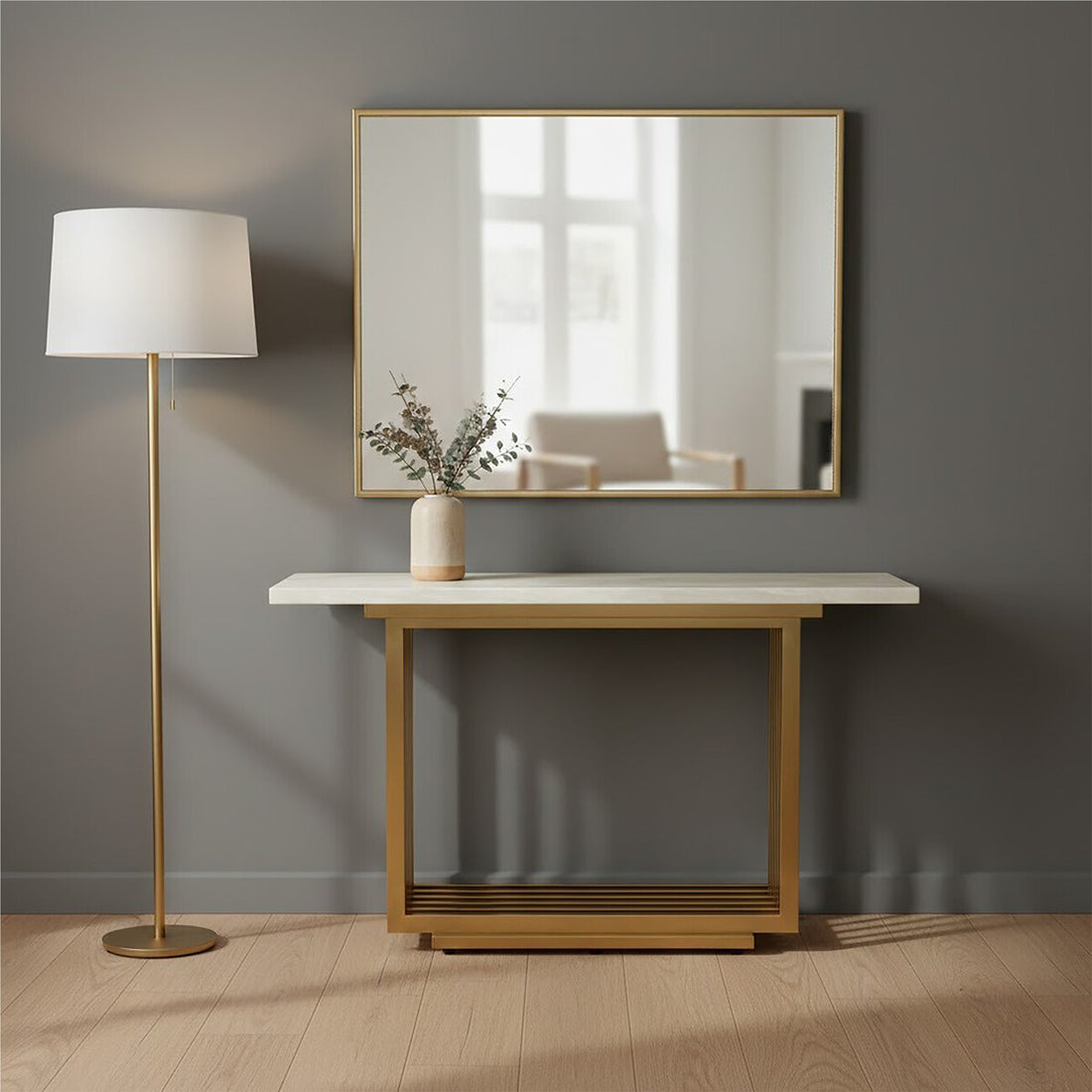 Console table with marble top and gold frame next to a floor lamp against a gray wall.