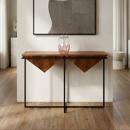 Wooden console table with a vase on top in a room with abstract art on the wall.