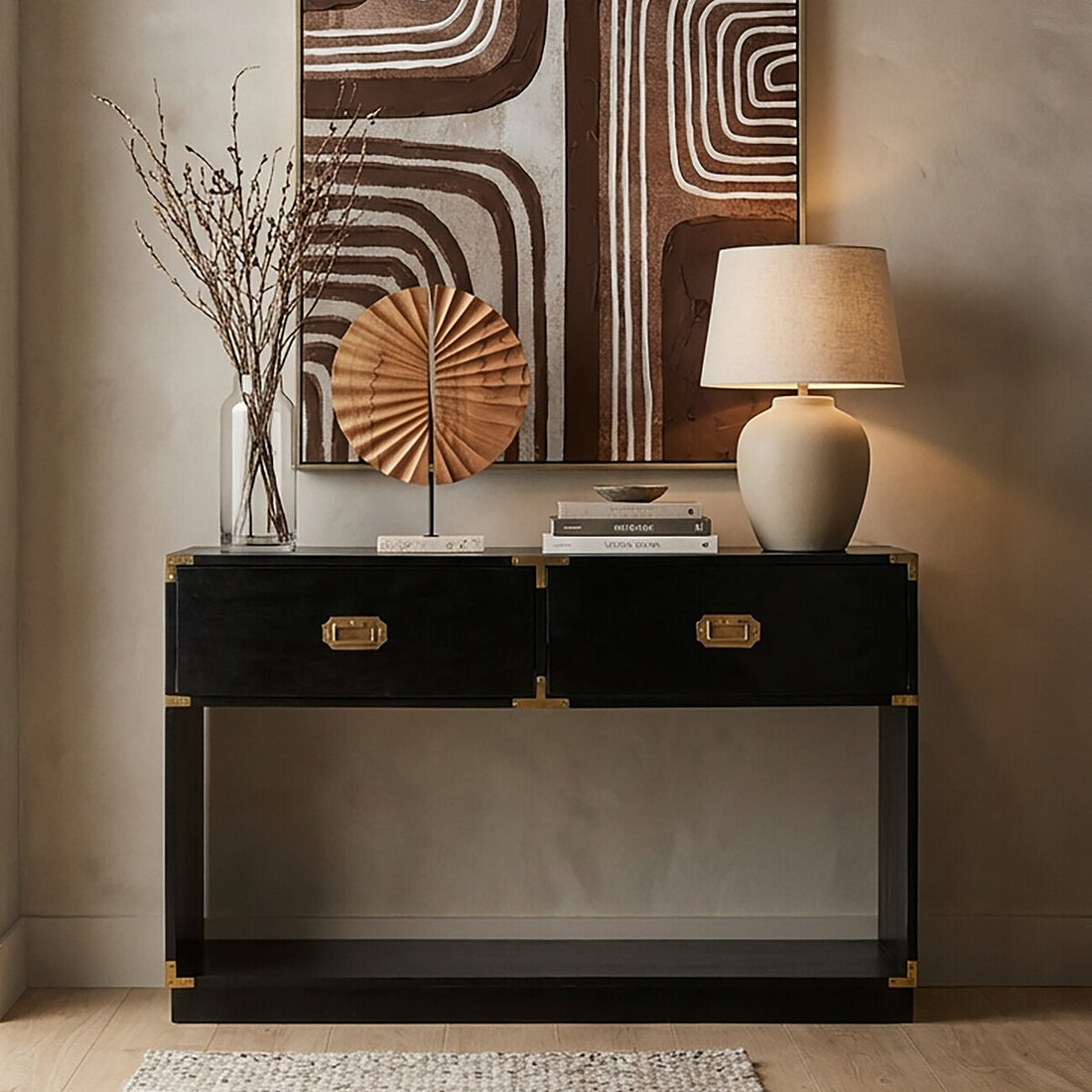 Black console table with gold accents against a wall with abstract art