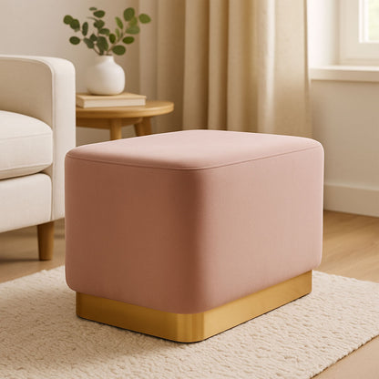 Pink ottoman with gold base in a living room setting
