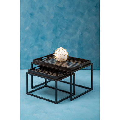 Black metal nesting tables with decorative sphere on a blue textured background