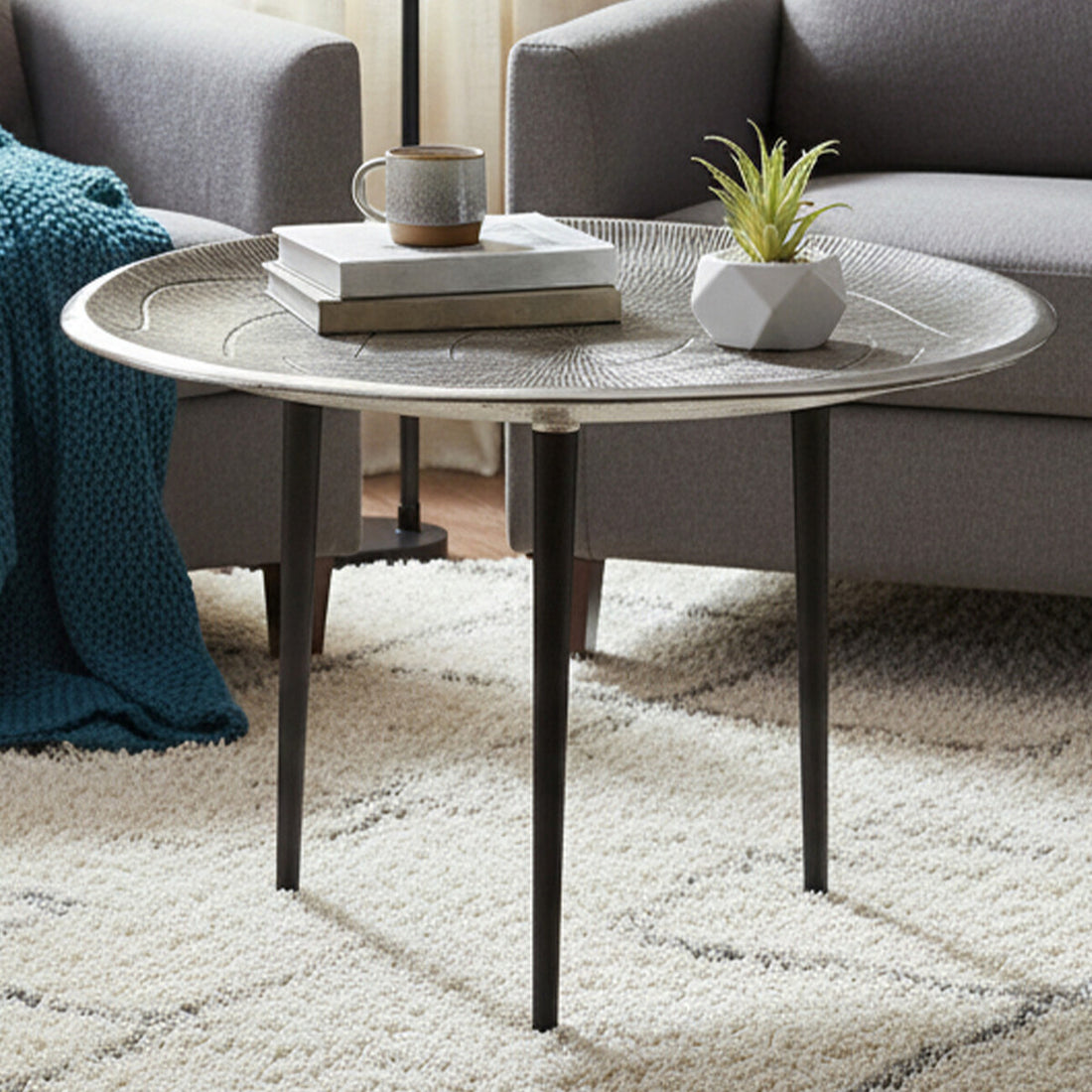 Round coffee table with decorative items in a living room setting