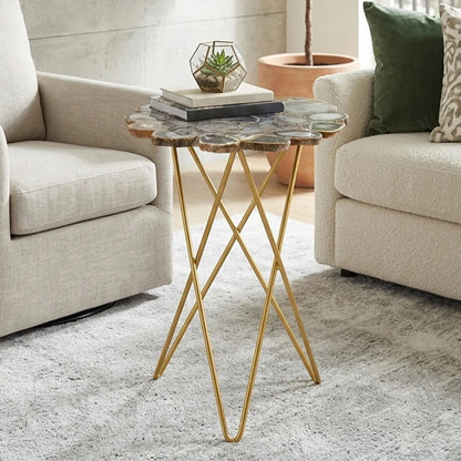 Small side table with gold legs and stone top in a living room setting