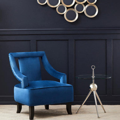 Blue armchair in a room with decorative wall art and a small table.