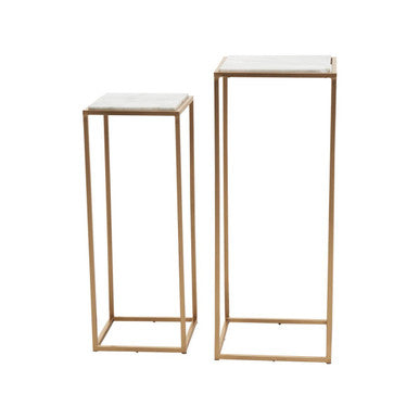 Two gold metal plant stands with white marble tops on a white background