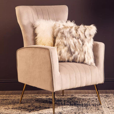 Beige armchair with fur-patterned cushions against a dark wall.