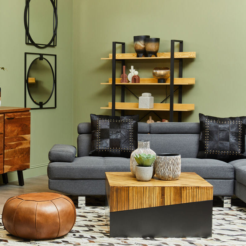 Living room with gray sectional sofa, wooden coffee table, and decorative items.