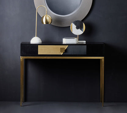 Modern console table with decorative mirror and lamps against a dark wall