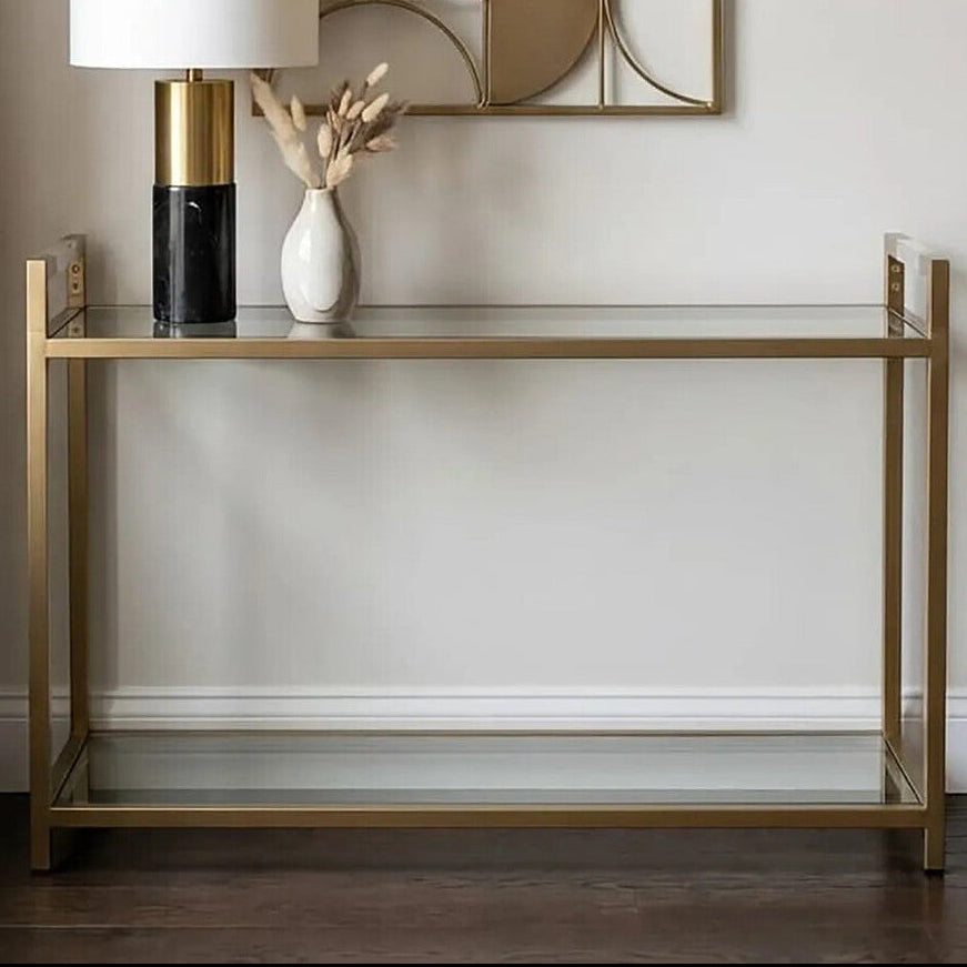 Gold console table with decorative items against a white wall