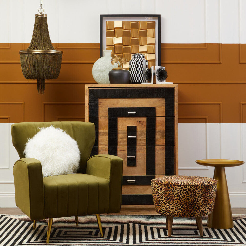 Modern living room with green armchair, wooden side table, and decorative items.