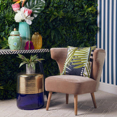 Decorative interior setting with a chair, table, and plants against a living wall.