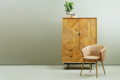 Wooden cabinet with geometric pattern and matching chair against a light green wall.